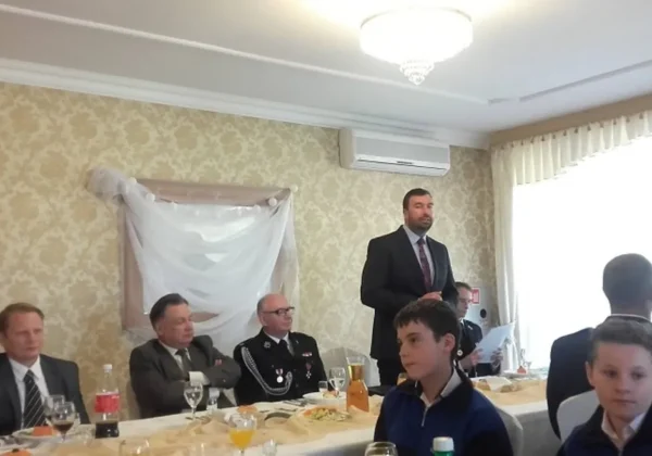 Uroczysty bankiet z udziałem członków OSP ze Słupna i samorządowców, podczas którego stojący mężczyzna w garniturze wygłasza przemówienie.