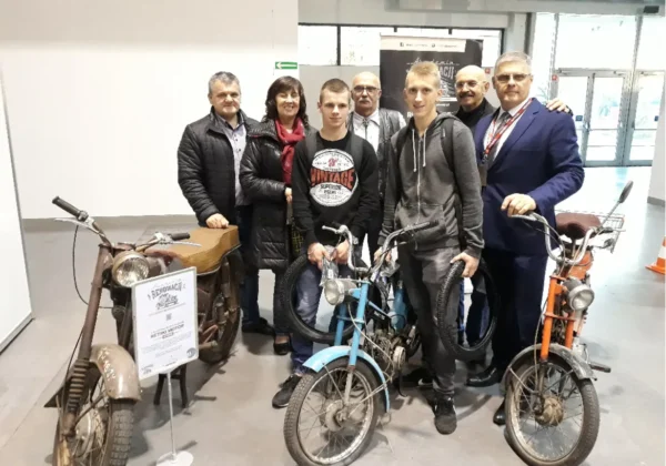 Grupa uczniów Zespołu Szkół im. Stanisława Staszica w Gąbinie z nauczycielami podczas wycieczki branżowej, stojąca przy zabytkowych motocyklach w muzeum.