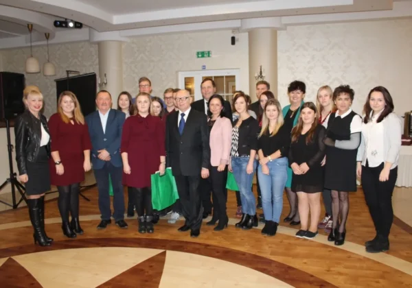 Grupa uczestników VI Konferencji Partnerstwa Lokalnego powiatu płockiego na rzecz ożywienia społeczno-gospodarczego i aktywizacji rynku pracy stoi razem na sali konferencyjnej w formalnych strojach.
