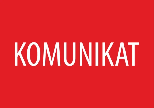 Czerwony plakat z dużymi białymi literami, na którym widnieje słowo „KOMUNIKAT”.