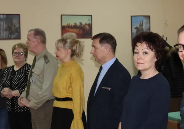 Grupa osób w formalnych strojach stoi w rzędzie podczas rozpoczęcia kwalifikacji 2018.
