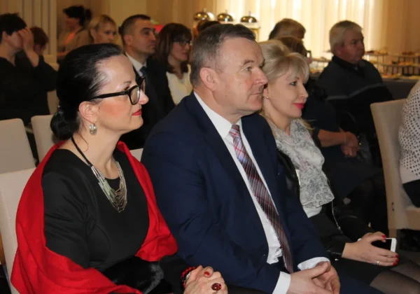 Na sali podczas panelu konsultacyjno-doradczego dotyczącego aktywizacji społeczno-zawodowej osób wykluczonych w powiecie płockim, w pierwszym rzędzie siedzą trzy osoby: kobieta w czarnej kreacji z czerwonym szalem, mężczyzna w granatowym garniturze i kobieta z blond włosami.