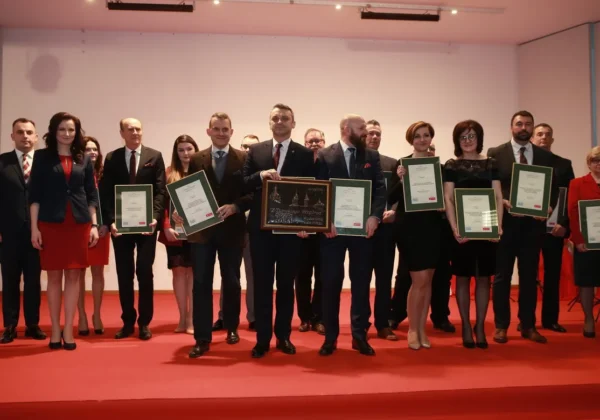 Grupa laureatów XI edycji gali „Z Tumskiego Wzgórza” stoi na scenie, trzymając certyfikaty i nagrody.