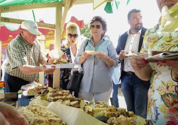 Uczestnicy Powiatowego Dnia Ziemi w Słubicach stoją przy stoisku z wypiekami i degustują ciasta.