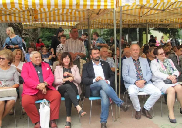 Uczestnicy XXV Dnia Humoru i Satyry w Domu Pomocy Społecznej w Zakrzewie siedzą pod żółto-białymi namiotami podczas uroczystości.