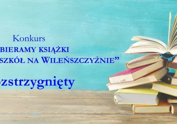 Stos książek na drewnianym stole na tle niebieskiej ściany z napisem „Konkurs Zbieramy książki dla polskich szkół na Wileńszczyźnie” — Rozstrzygnięty.