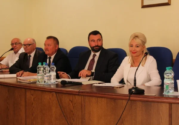 Uczestnicy XXXVII sesji Rady Powiatu siedzą przy stole w sali konferencyjnej, omawiając wsparcie dla OSP, suszę i drogi.