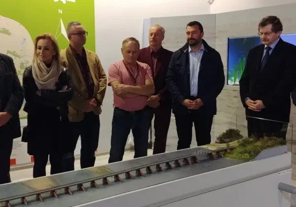 Grupa osób stojących obok makiety ukazującej teren nad wodą na nowej wystawie Muzeum Wisły Środkowej i Ziemi Wyszogrodzkiej.