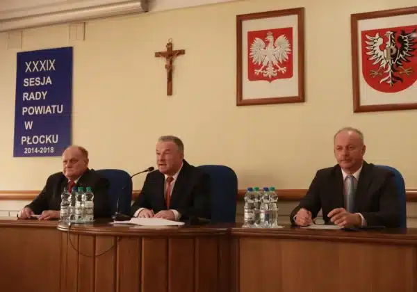 Na zdjęciu widać trzech mężczyzn siedzących za stołem podczas XXXIX sesji Rady Powiatu w Płocku, która koncentruje się na tematyce oświaty.