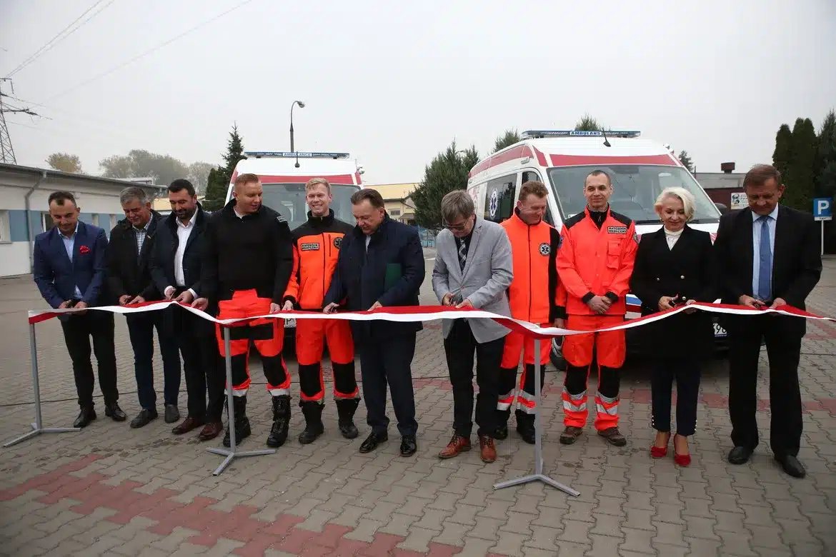 Uroczyste przecięcie wstęgi z okazji przekazania dwóch nowych karetek dla Gąbina i Wyszogrodu, z obecnością przedstawicieli lokalnych władz oraz personelu medycznego.