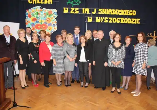 W wydarzeniu „Dzień Chleba” w Zespole Szkół im. J. Śniadeckiego w Wyszogrodzie uczestniczyli przedstawiciele społeczności lokalnej i pedagogicznej, pozując do wspólnego zdjęcia.