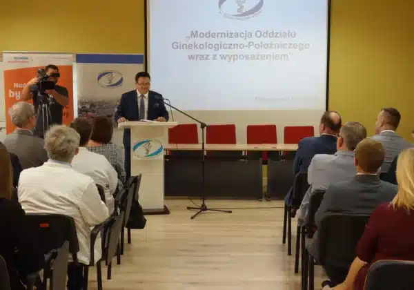Na zdjęciu przedstawiono oficjalne otwarcie zmodernizowanego Oddziału Ginekologiczno-Położniczego w płockim Szpitalu Wojewódzkim, z mówiącym przedstawicielem i obecnymi gośćmi.