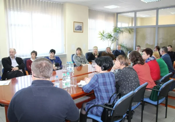 Ukraińscy goście siedzą przy długim stole w sali konferencyjnej Powiatowej Poradni Psychologiczno-Pedagogicznej w Płocku podczas spotkania.