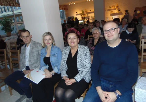 Czterech gości siedzi w pierwszym rzędzie w sali podczas otwarcia lokalu Płockie Gary Babci Krysi.