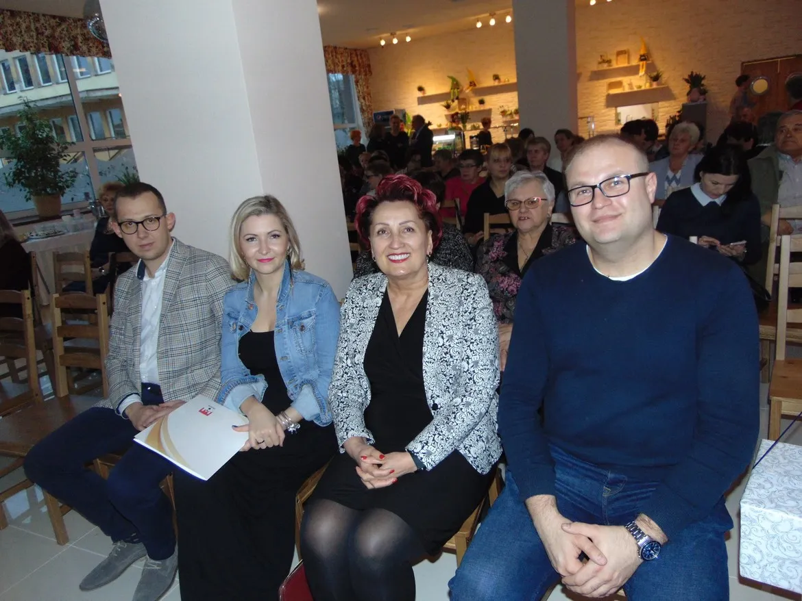 Czterech gości siedzi w pierwszym rzędzie w sali podczas otwarcia lokalu Płockie Gary Babci Krysi.