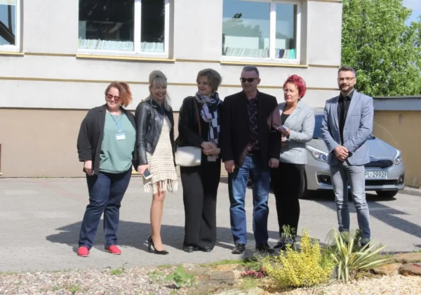 Grupa sześciu osób stoi przed budynkiem Starostwa Powiatowego w Płocku, wśród nich gość z Kijowa.