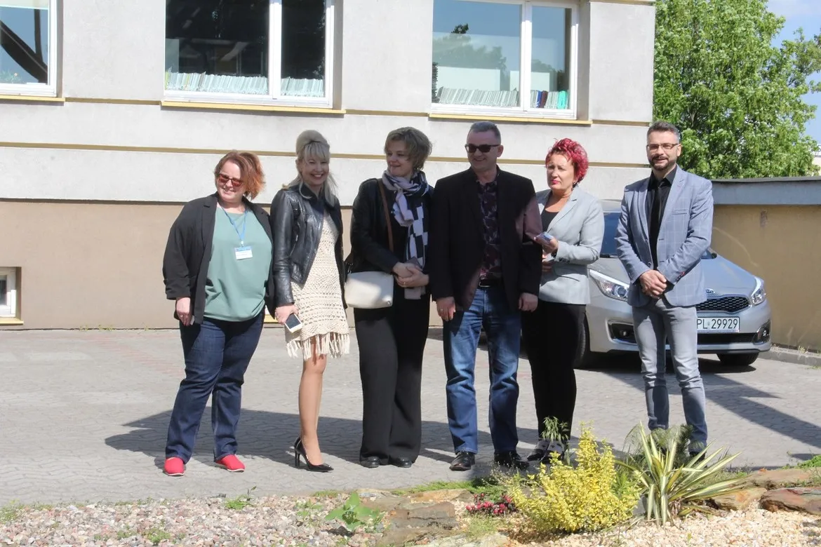 Grupa sześciu osób stoi przed budynkiem Starostwa Powiatowego w Płocku, wśród nich gość z Kijowa.