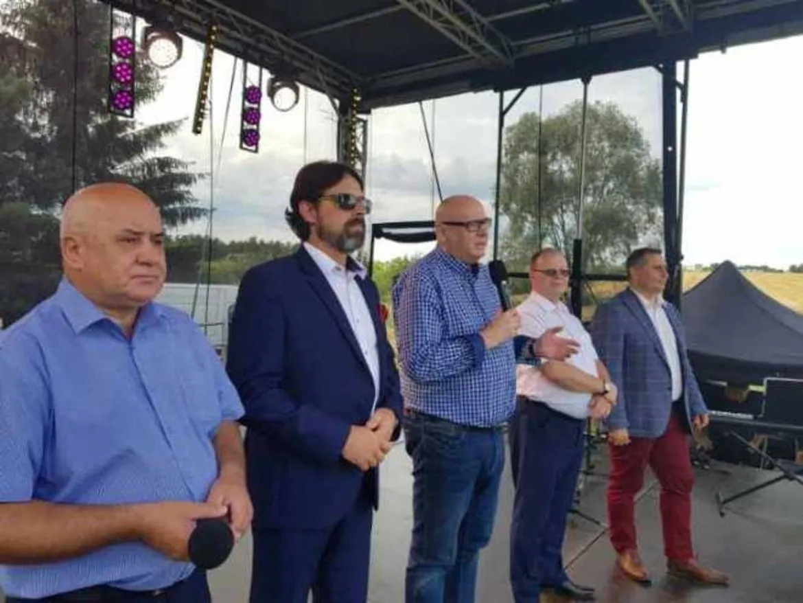 Pięciu mężczyzn stoi na scenie podczas II Jarmarku Łęski w gm. Drobin; jeden z nich przemawia do mikrofonu.