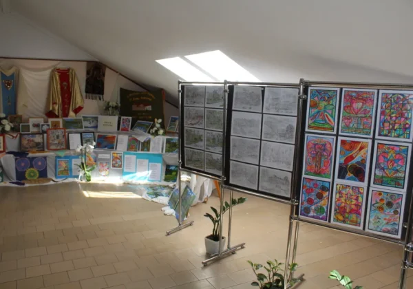 Wernisaż prac w Domu Pomocy Społecznej w Koszelewie – sala wystawowa z tablicami prezentującymi rysunki i kolorowe prace plastyczne.