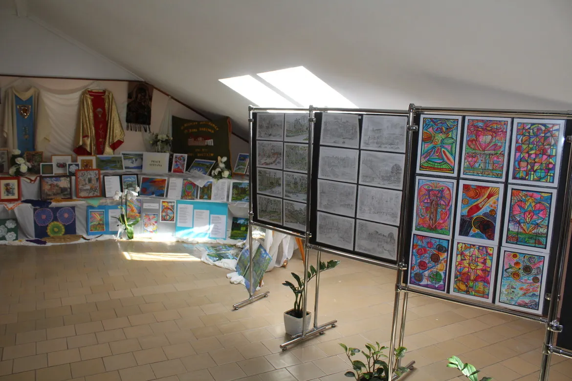 Wernisaż prac w Domu Pomocy Społecznej w Koszelewie – sala wystawowa z tablicami prezentującymi rysunki i kolorowe prace plastyczne.