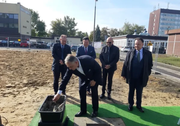 Grupa mężczyzn w garniturach podczas ceremonii wmurowania kamienia węgielnego pod budowę Kompleksu Opieki Długoterminowej i Hospicyjnej w Wojewódzkim Szpitalu Zespolonym w Płocku.