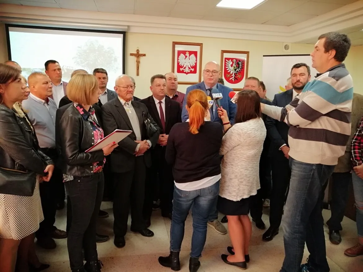 Grupa samorządowców i dziennikarzy podczas konferencji prasowej w Powiecie Płockim, omawiającej temat suszy i braku pogłębiania rzeki Wisły.