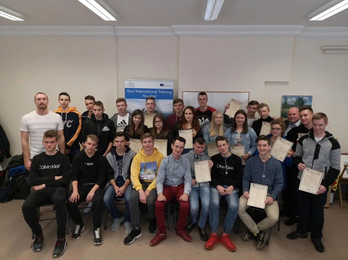 Grupa uczniów i nauczycieli Zespołu Szkół im. Jana Śniadeckiego w Wyszogrodzie podczas inauguracji praktyk zawodowych dwóch 12-osobowych mobilności, wszyscy trzymają certyfikaty.