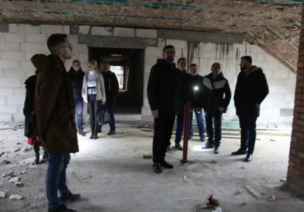 Grupa osób zwiedza wnętrze odbudowywanego DPS Nad Jarem w Nowym Miszewie.