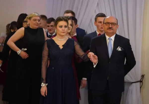 Para w wieczorowych strojach prowadzi za rękę grupę uczniów podczas uroczystego wieczoru w Zespole Szkół im. Leokadii Bergerowej w Płocku.