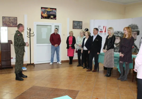 Żołnierz w mundurze wojskowym przemawia do stojącej w rzędzie grupy osób podczas kwalifikacji wojskowej 2020.
