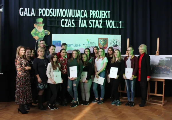 Grupa uczestników i organizatorów na scenie podczas gali podsumowującej projekt „Czas na staż vol.1”, część osób trzyma certyfikaty.