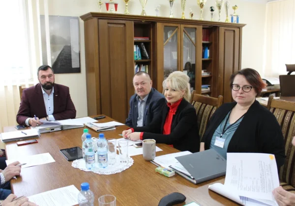 Czterech uczestników spotkania w biurze omawia dokumenty dotyczące bezpieczeństwa pożarowego w 2019 roku.
