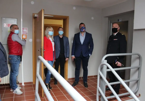 Grupa osób w maseczkach stoi w korytarzu przed wejściem do Domu Pomocy Społecznej Nad Jarem w Nowym Miszewie, witając mieszkańców po ich powrocie.