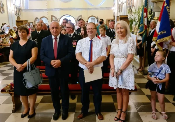Grupa uczestników w formalnych strojach stoi w kościelnym wnętrzu podczas uroczystości upamiętniającej Bitwę Warszawską 1920 w Drobinie.