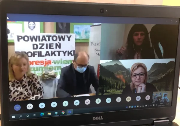 Zrzut ekranu z wideokonferencji podczas Powiatowego Dnia Profilaktyki „Depresja – wiem, rozumiem, działam”, z trzema panelami wideo, bannerem w tle i listą uczestników na dole.