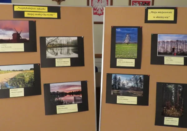 Dwie tablice wystawowe z kilkoma nagrodzonymi fotografiami i podpisami autorów, prezentujące wyniki XII edycji Powiatowego Konkursu Fotograficznego.