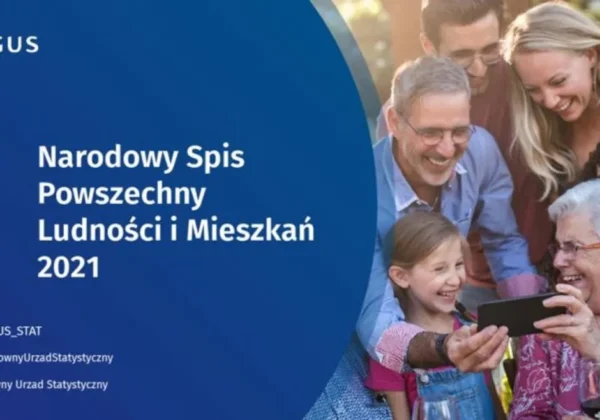 Grupa ludzi robiących sobie wspólne zdjęcie telefonem, na tle niebieskiego baneru z napisem Narodowy Spis Powszechny Ludności i Mieszkań 2021.