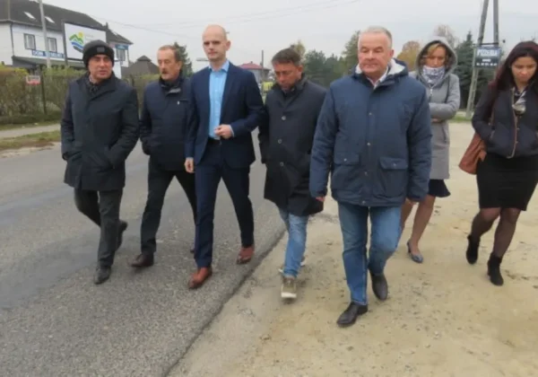 Grupa samorządowców Powiatu Płockiego spaceruje po ulicy w Gminie Brudzeń Duży podczas wizyty.