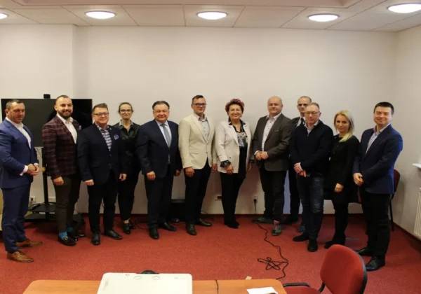 Grupa kilkunastu osób w garniturach i marynarkach stoi razem w sali konferencyjnej podczas podpisywania porozumienia o modernizacji dróg łączących Płock i Powiat Płocki.