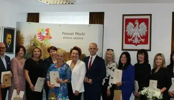 Uroczystość z okazji XXIV Powiatowego Dnia Edukacji Narodowej, z grupą nauczycieli i przedstawicieli władz, którzy otrzymują wyróżnienia.