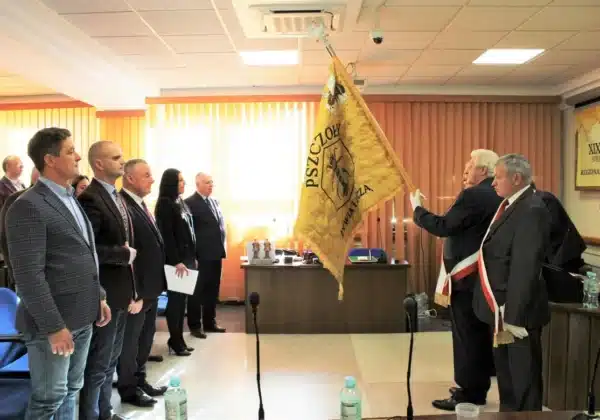 Członkowie Polskiego Związku Pszczelarzy w Płocku uczestniczą w ceremonii w Starostwie Powiatowym, gdzie przedstawiane są flagi i symbole pszczelarstwa.