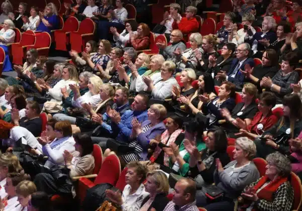 Grupa osób wśród publiczności, z entuzjazmem klaskająca w czasie wydarzenia.