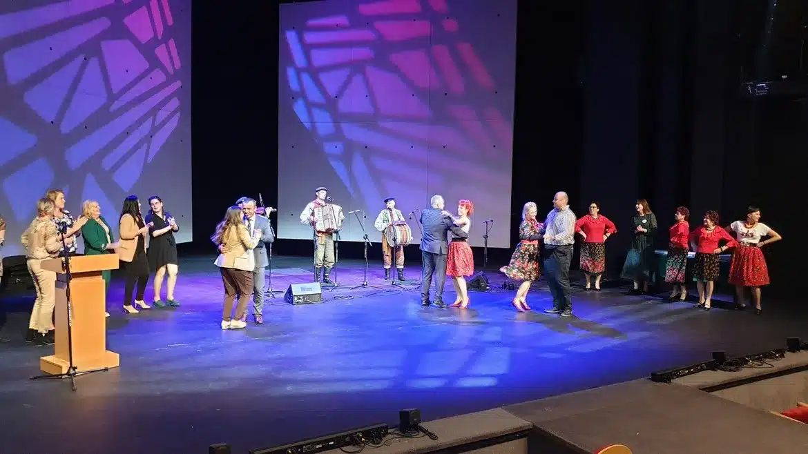 Na zdjęciu widać uczestników I Kongresu Kół Gospodyń Wiejskich, którzy tańczą i bawią się na scenie przy akompaniamencie muzyków.