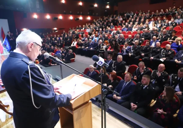 Mężczyzna w mundurze strażackim przemawia z podium podczas jubileuszu 25-lecia Oddziału Powiatowego Związku Ochotniczych Straży Pożarnych w Płocku, przed zgromadzoną widownią.