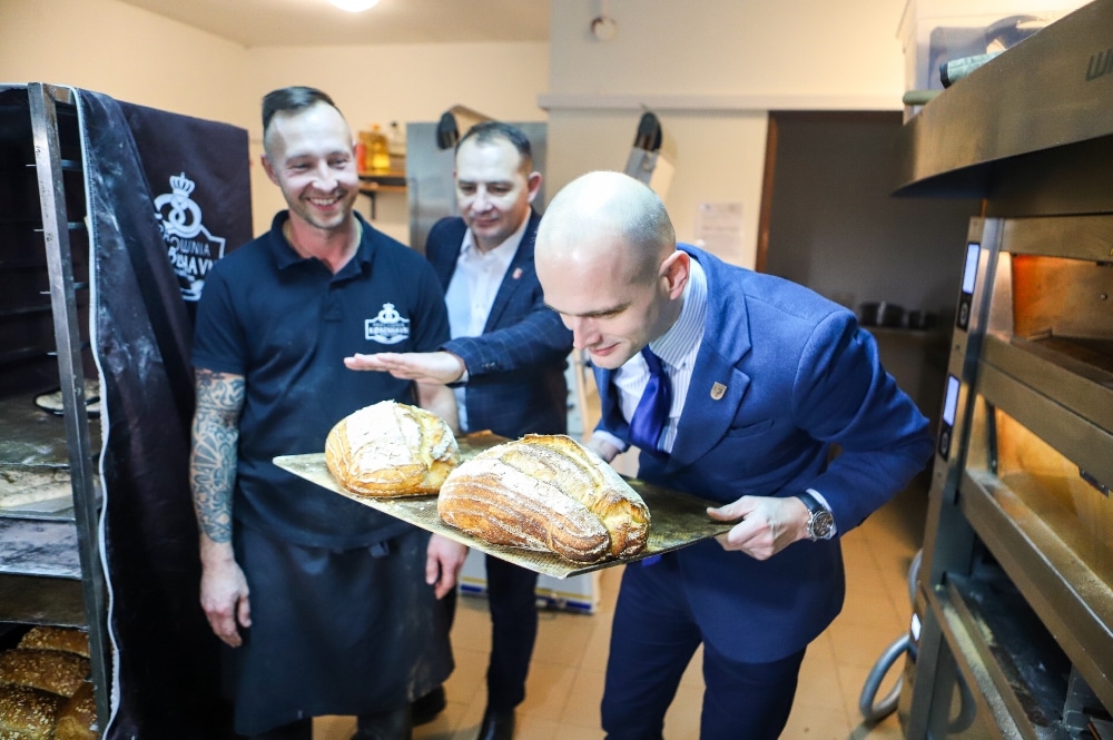 Starosta pochylający się nad bochnem chleba