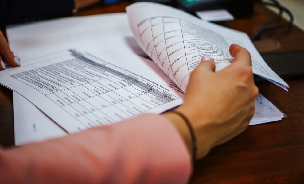 Osoba przeglądająca wydrukowaną prognozę finansową