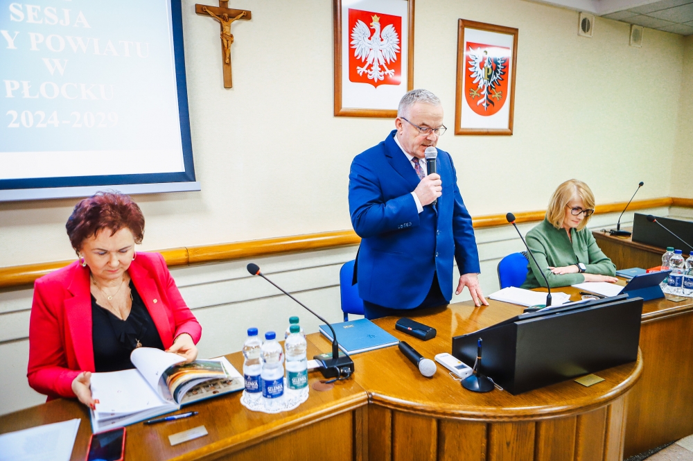 Przewodniczący Sesji Rady Powiatu z mikrofonem w dłoni