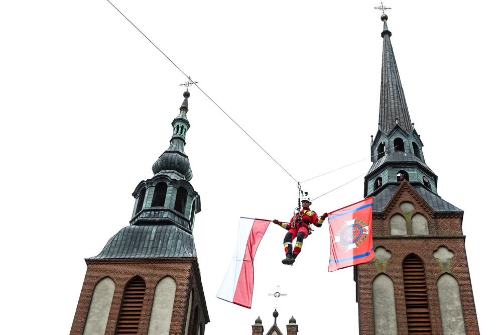Strażak zjeżdżający na linie z wieży kościoła w bielsku