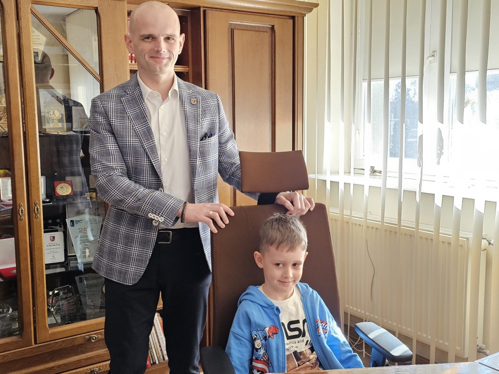 Starosta wraz z przedszkolakiem zasiadającym na fotelu starosty
