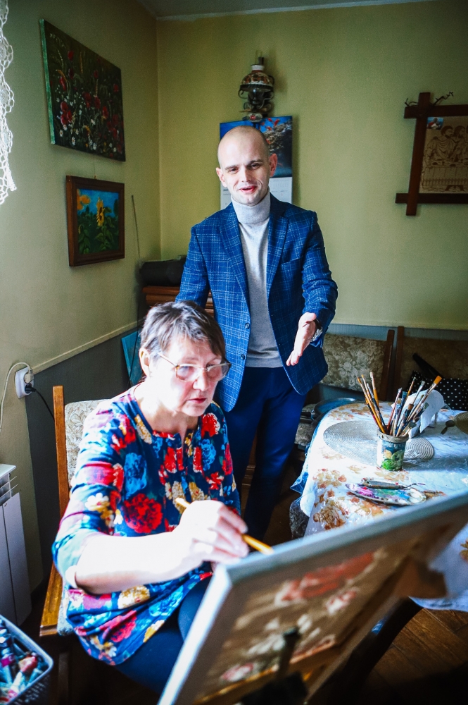 Starosta podziwiający pracę malarki